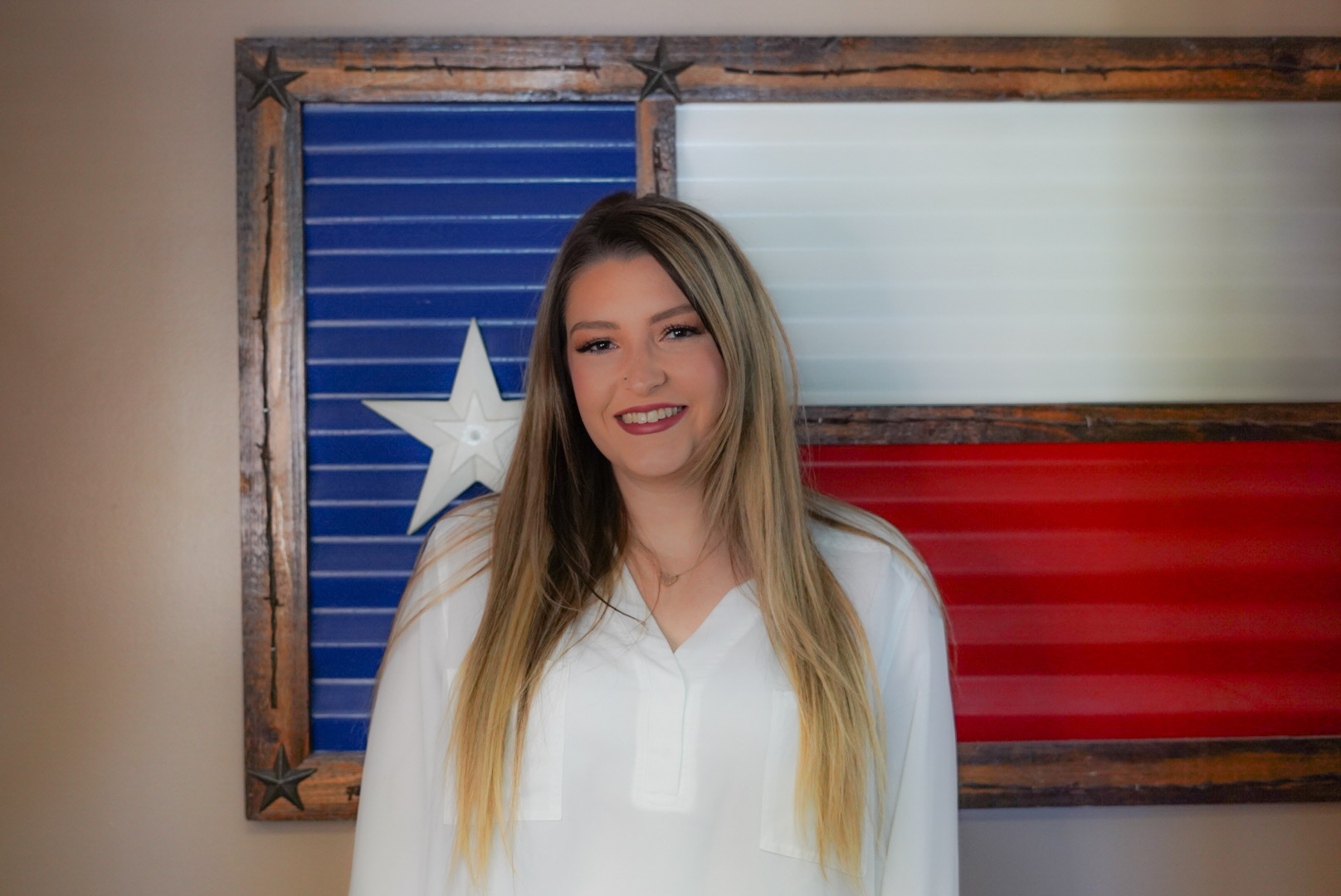 Brittany standing in front of a metal Texas flag