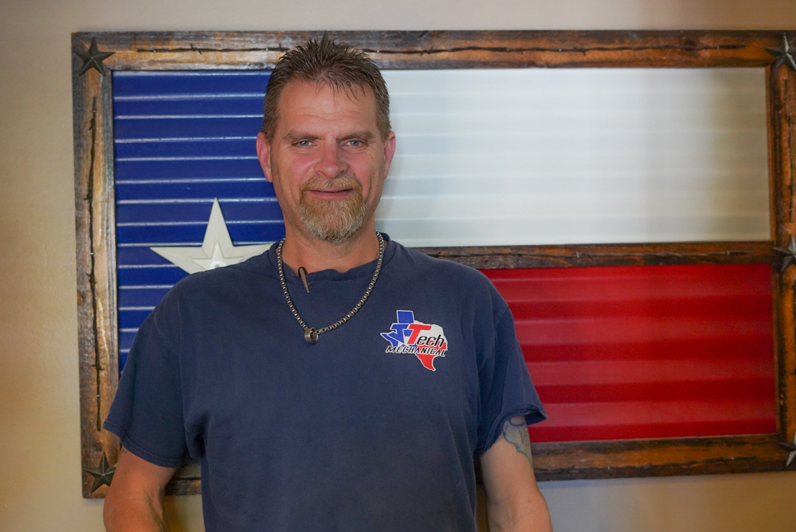 Dean standing in front of a metal Texas flag